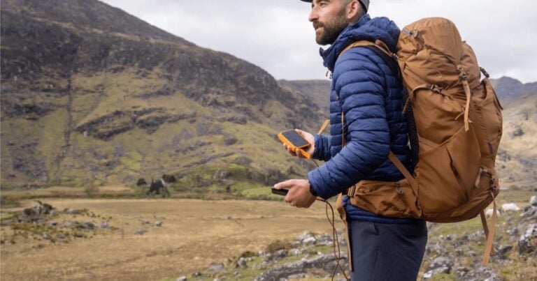 Hiker using an outdoor power bank in the mountains
